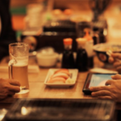A group of friends dining at an izakaya bar