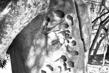<p>Stone monument near the pond with kanji&nbsp;lettering carved into the stone</p>