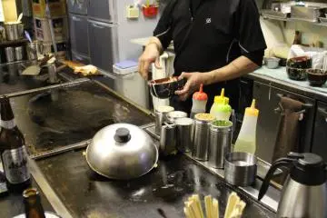<p>เจ้าของร้านกำลังทำโอโคโนะมิยากิ</p>