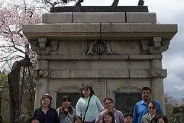International visitors from Beaver Village, Alaska pose with GOZAIN volunteer guides in front of the Date Masamune statue on Aobayama. (Photo: GOZAIN)