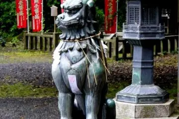 Statue of strange horned beast beside metal lantern