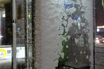 <p>A telephone booth draped in snow</p>