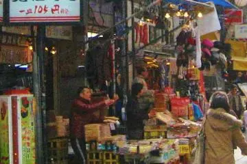 Dried fish, beans and nuts next to hats and coats
