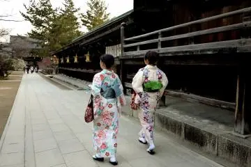 <p>The woman on the left has plum blossom on her kimono</p>