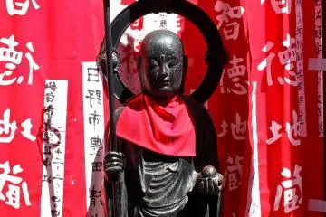 <p>Buddhist stature surrounded by prayer banners donated by temple members</p>