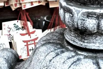 <p>Prayer boards behind a stone lantern</p>
