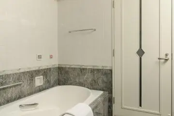 Even the door to the bathroom is stylish, and the lovely stone that lines the walls adds to the classy design.