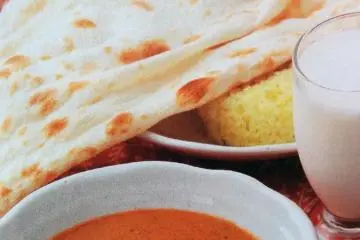 <p>A picture of a popular lunch set: naan bread and rice, curry, salad, and your choice of drink.&nbsp;</p>