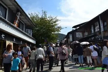 <p>ทางเดินสู่วัดที่เต็มไปด้วยร้านค้าและผู้คน</p>