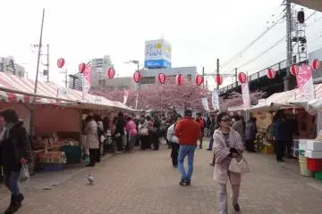 Otros disfrutan comprar comida local servida en los stands bajo las tiendas blancas junto a la estación.