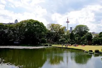 <p>Kyoto Tower and modern&nbsp;buildings over the garden</p>