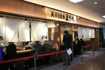 <p>หน้าร้านที่มีที่กั้นสำหรับต่อแถวยาว</p>