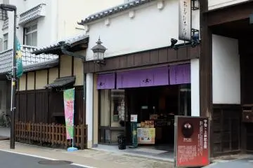 <p>ด้านหน้าร้าน หาไม่ยาก เดินจากสถานี JR Uji เลี้ยวซ้ายมาตามถนนเส้นหลัก จะเห็นร้านที่มีผ้าสีม่วง ใช่เลย!</p>