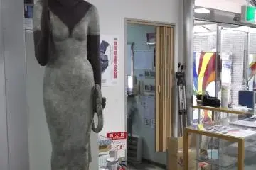 <p>This woman is standing serenely near the entrance</p>