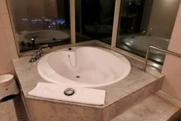 <p>Heart-shaped bathtub with glass window overlooking the lit-up Great Akashi Strait Bridge</p>
