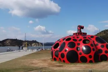 งานศิลปเริ่มขึ้นที่ท่าเรือมิยะโนะอุระ ด้วยฟักทองสีแดงขนาดใหญ่ของ Yayoi Kusama 