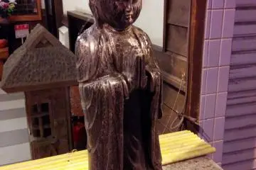 <p>Pouring water over Kannon, the goddess of mercy, is a ritual observed by visitors to this small prayer area setup where a storefront would usually be.&nbsp;</p>