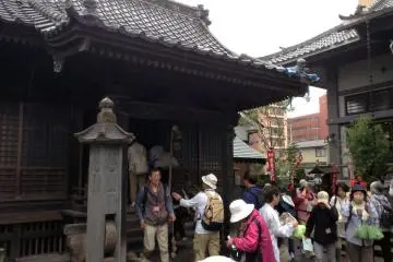 <p>A group gathers around the temple to give thanks and to ask for blessings</p>