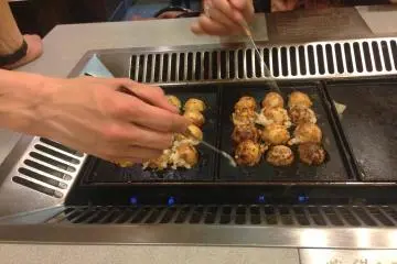 Once it is ready, turn the balls around with a skin of crispy grilled batter on the outside, and a hot lava like gooey mess of octopus and cheese doughy goodness on the inside