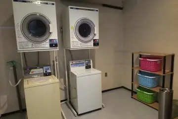 <p>Laundry room with coin-operated washing machines and drying machines, though a laundry service is also available.</p>