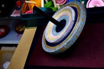 <p>Beautiful spinning top made of Nishijin Kimono Sash fabric. I asked if it's made by 'leftovers' of Kimono Sash, as Nishijin Sash is very expensive, but according to the Maestro, the material was custom-made just for this Koma, the spinning top!</p>
