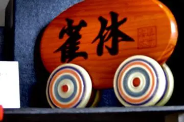 <p>Shop name on wooden plaque, 'Jackyu', which means a sparrows' resting place</p>