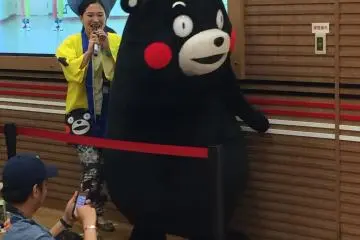 <p>Kumamon makes his way to the stage with his mate. Because he can't speak, his mate interprets in Kumamoto dialect.</p>