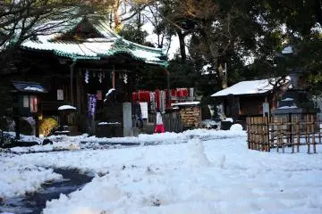 <p>This is a wider view of the main building of the shrine, as well as how the Sun hits it through the various trees that are around it. In the foreground you can see a small snowman.&nbsp;</p>