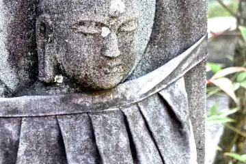 <p>An old plastic bib protects the statue from the elements</p>