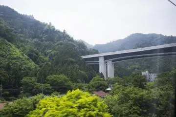 Elevated train tracks nestled among beautiful mountains on the journey from Hachioji to Matsumoto