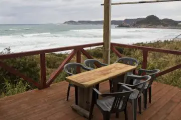 <p>Outdoor seating looks onto the incoming waves</p>