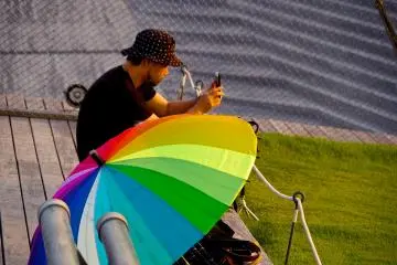 <p>ร่มสีรุ้งกับผู้ที่ชื่นชอบการชมอาทิตย์ยามอัสดง</p>