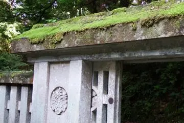 <p>Moss-covered stone roof of the cemetery gate. The crest of 'Paulownia of 5-7' is carved along with Matsudaira Family's crest, 'Circle Around Three Hollyhock Leaves'</p>
