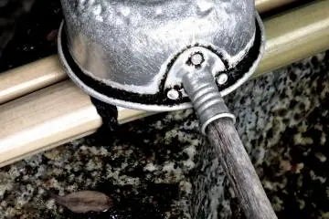 Dipping cup at the purification font