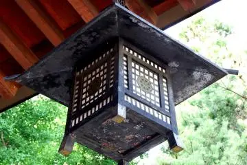 <p>Bronze lantern hanging from the roof of Shirahige Shrine</p>