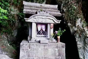 <p>Small stone shrine in the shadow of the mountain cave</p>