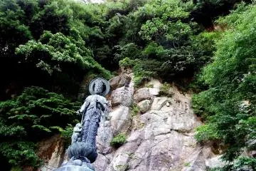 그녀의 뒤쪽에 벌거 벗은 바위가있는 자비의 여신상
