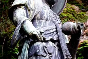 어린이를 함께 자비의 여신상 클로즈업, 한 아이가 그녀의 다리에 매달려 있다