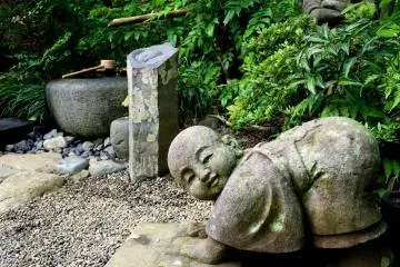 <p>Statue of child monk cleaning a floor</p>