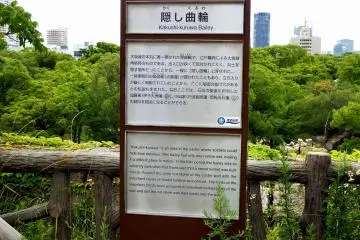 <p>The sign explaining the 'Kakushi-kuruwa Bailey'. This is the secret place used to 'hide' soldiers inside. The sign also says you can locate on some stones the family crests of Kato Family and Koide Family who were assigned to reconstruct the stone walls here</p>