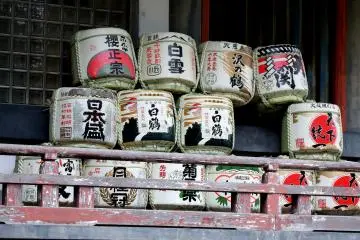 <p>Offerings of sake barrels are piled up on the outside corridor of the main hall</p>