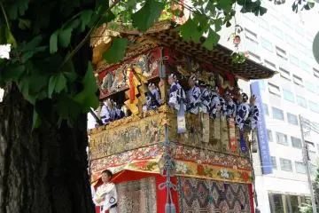 <p>Musicians playing matsuri music perch on the sides of the floats</p>