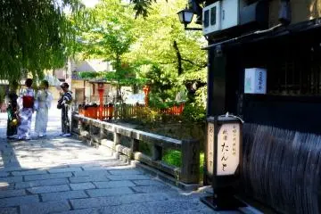 <p>Girls in summer kimono meet on a bridge in Gion</p>