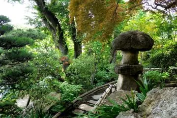 <p>Rough stone lantern looking over the garden from a small hill</p>