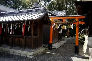 <p>A small red torii stands beside shrine buildings &nbsp;</p>