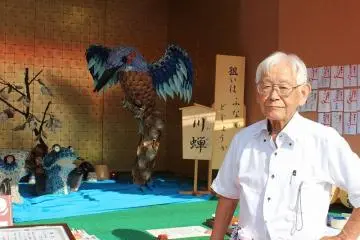 카나츠쵸 무이카구의 본진의 장식물을 시중드는 이나타 노부오씨. 도자기의 작은 접시를 사용하여 물총새와 물고기 조수희화 같은 장면을 그리고 있다