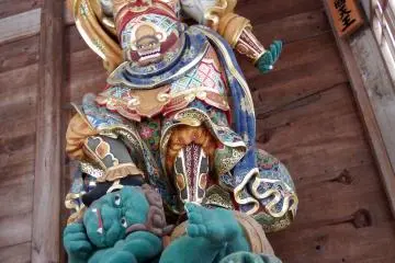 <p>Looking up at the King of East's statue between a gap of the wooden fence. He is stamping on a green fiend! You can't see it unless peeping in from below!</p>