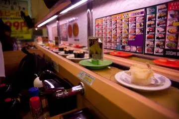 <p>ซูชิแสนอร่อยกำลังเดินทางบนโต๊ะของเรา บนสายพานลำเลียง</p>