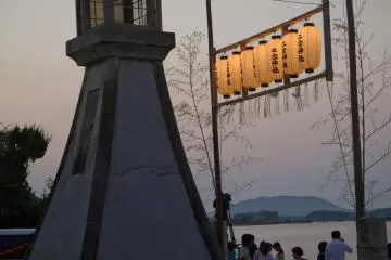 <p>A large stone lantern faces the sea</p>