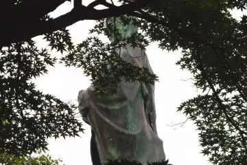 Rennyo's statue seen through dark trees